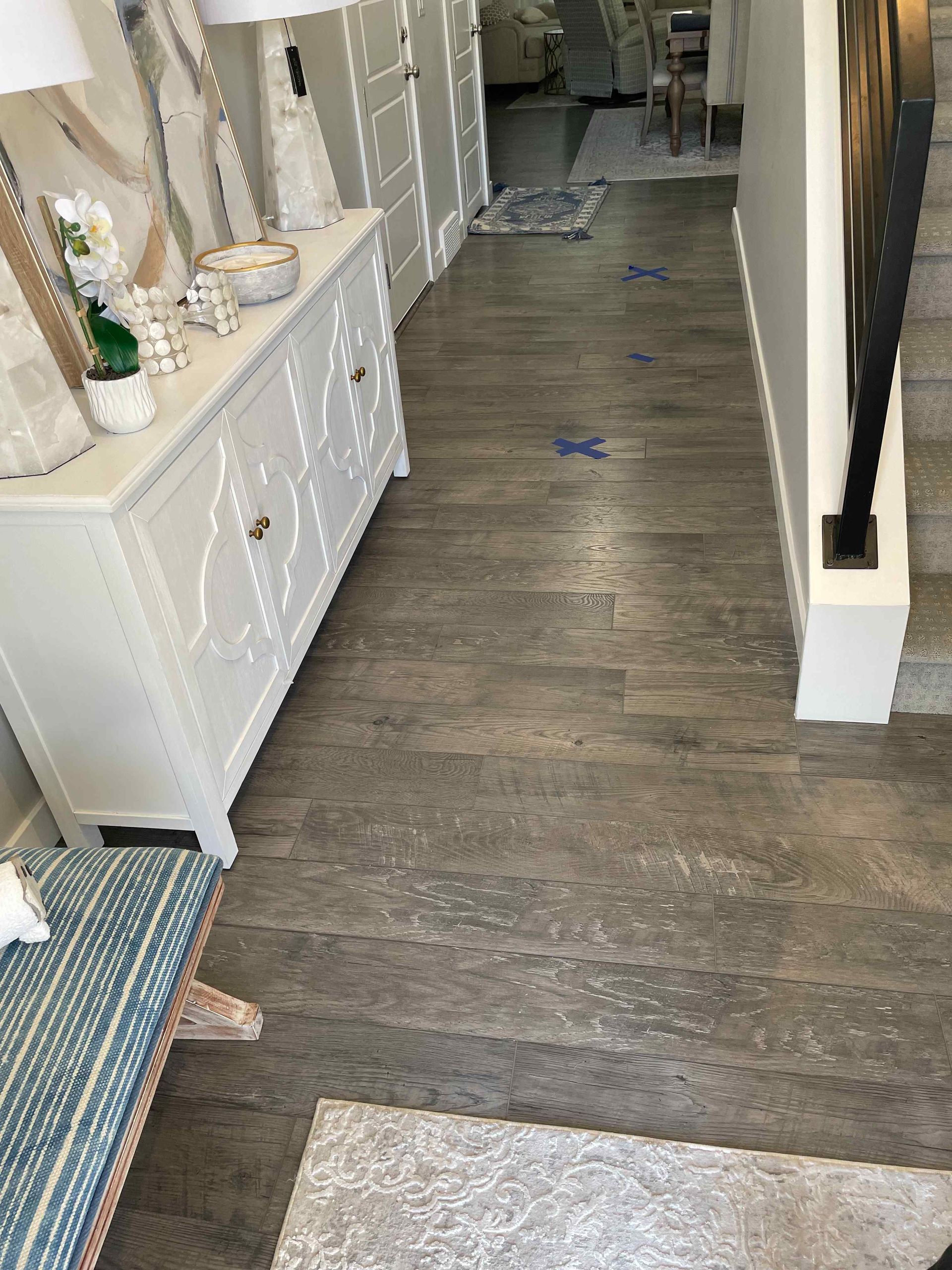 A hallway with wooden floors and a white dresser