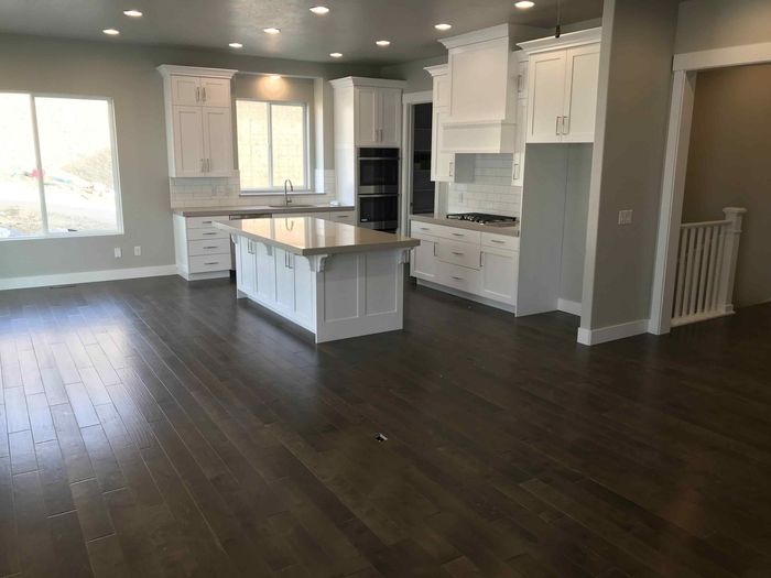 A kitchen with white cabinets and a large island in the middle of the room.