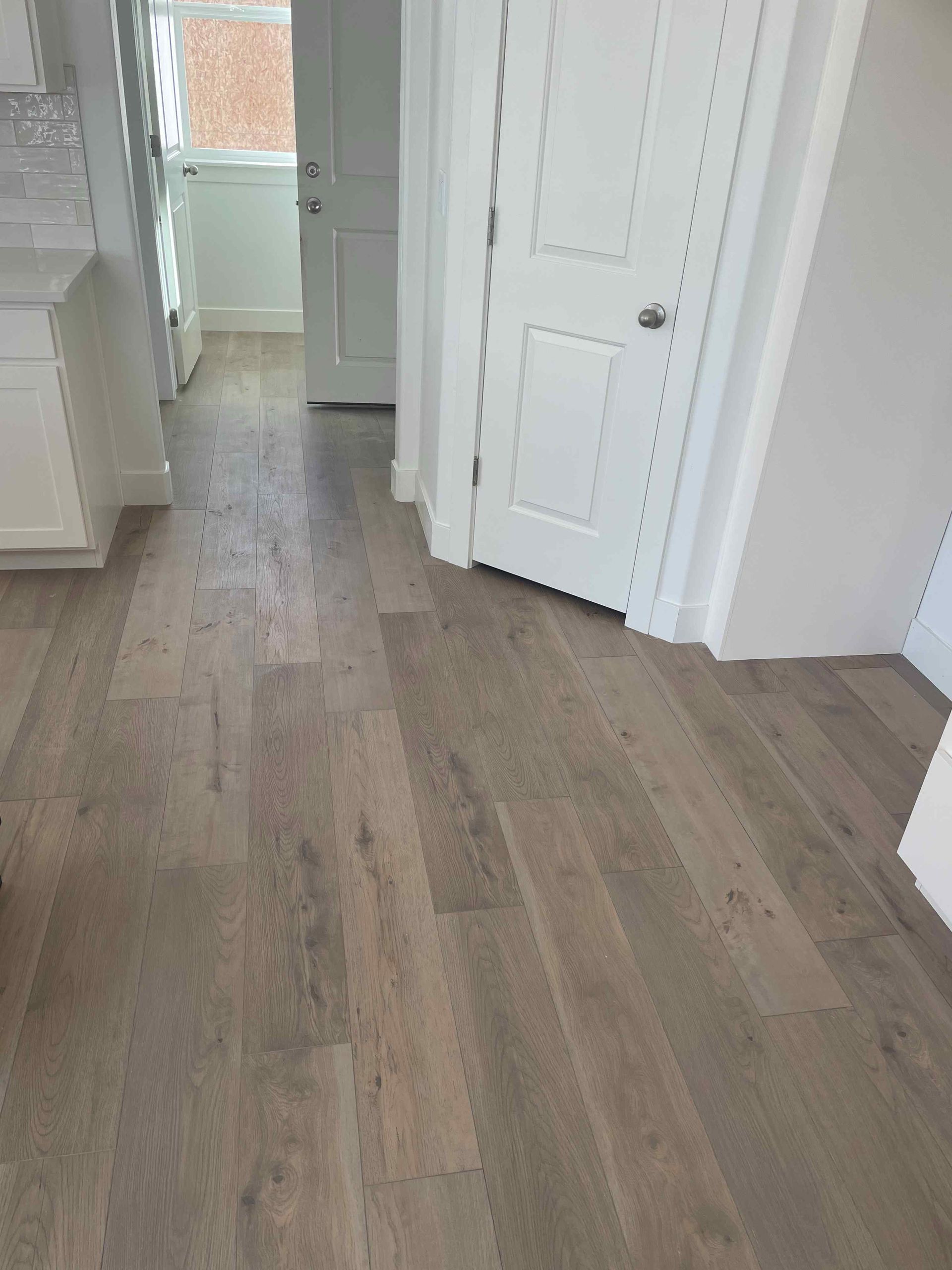 A kitchen with hardwood floors and white cabinets.