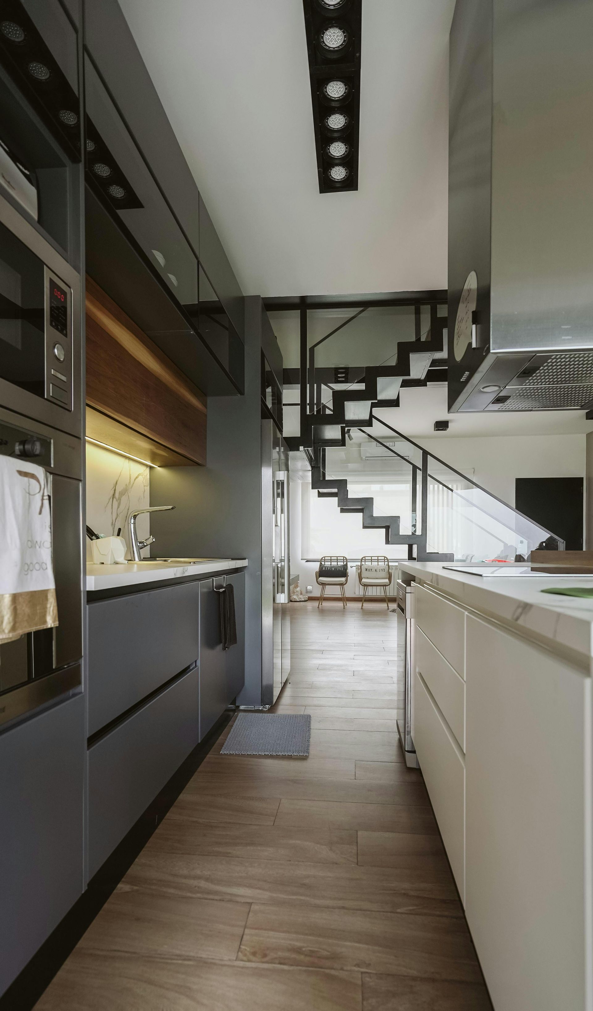 A kitchen with a staircase leading to the second floor.