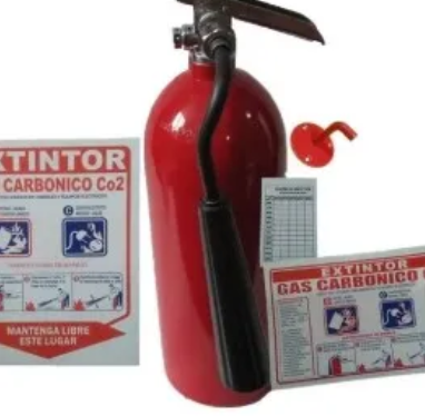Un extintor rojo junto a un cartel que dice extintor carbonico co2