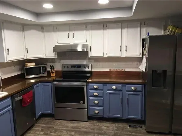 A kitchen with blue cabinets and stainless steel appliances A kitchen with blue cabinets and stainless steel appliances