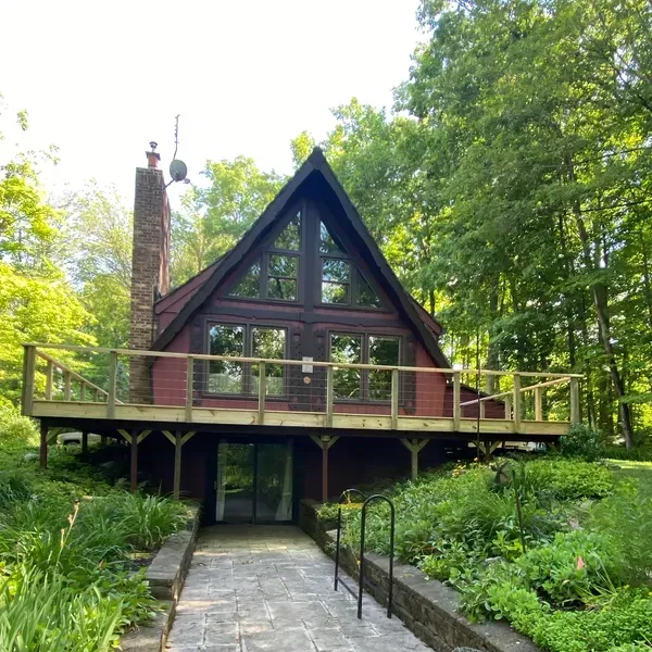 A red a frame house with a wooden deck