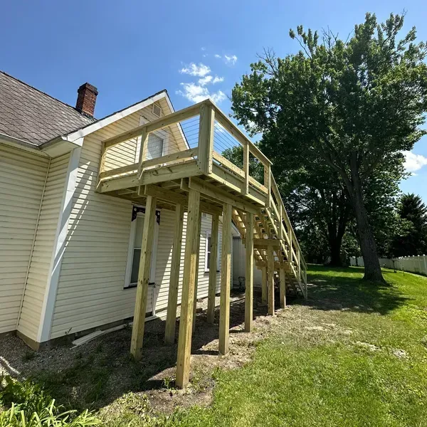 A white house with a wooden deck in front of it