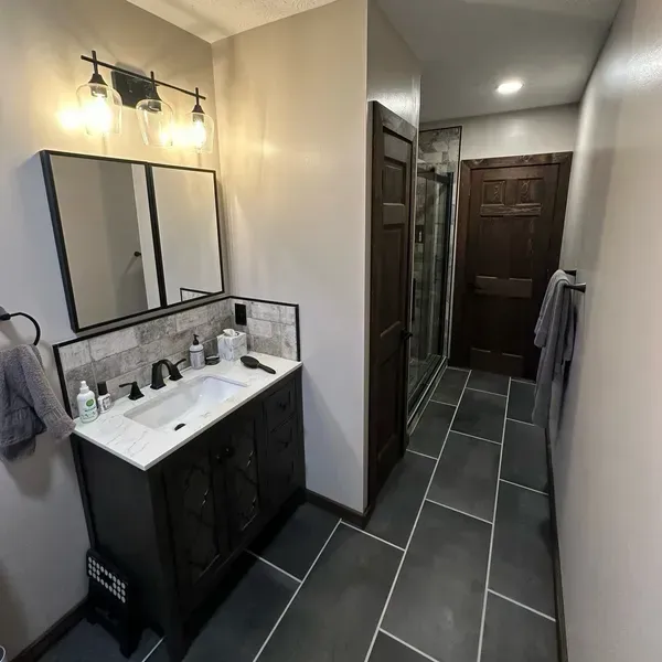 A bathroom with a sink and a mirror A bathroom with a sink and a mirror