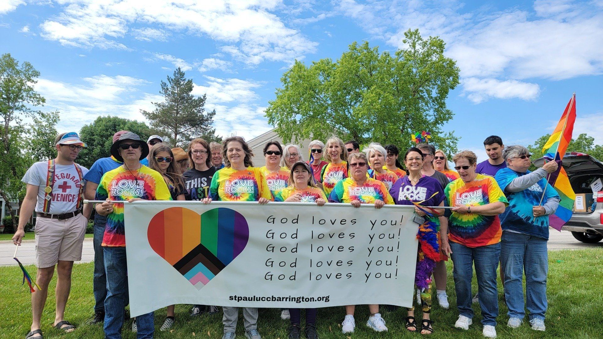 A group of people are standing in a field holding a peace sign.