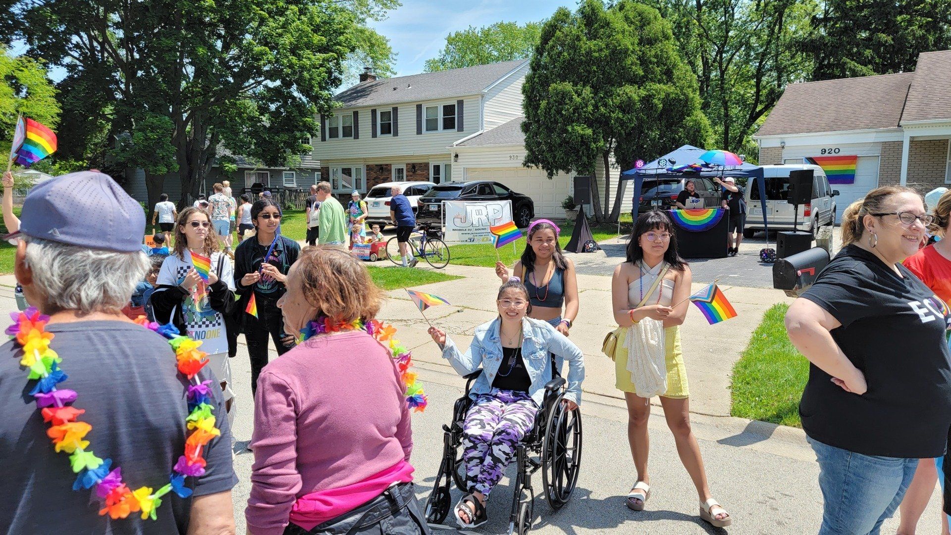 A woman in a wheelchair is surrounded by people at a parade.