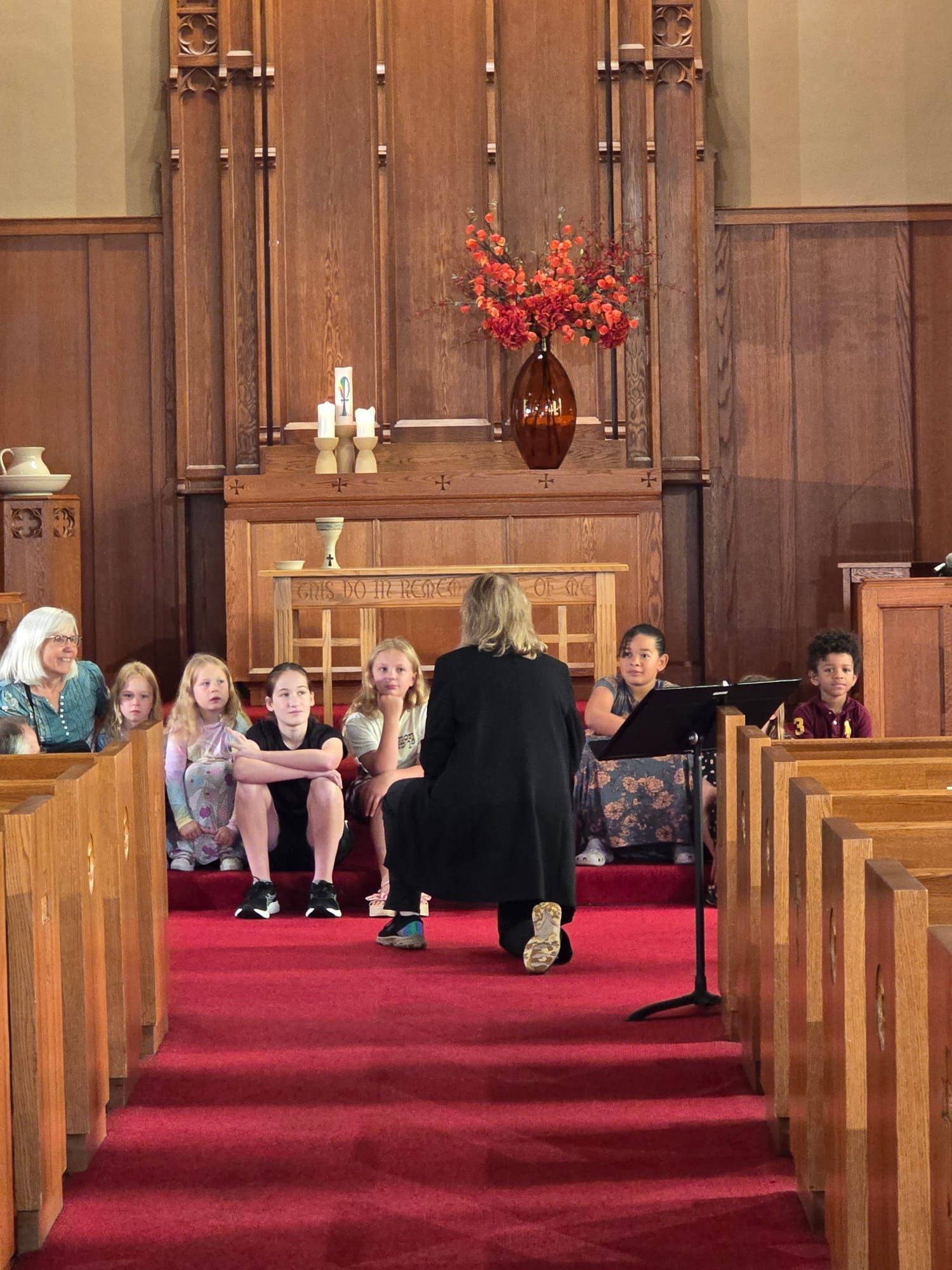 A group of children are sitting on the floor in a room.