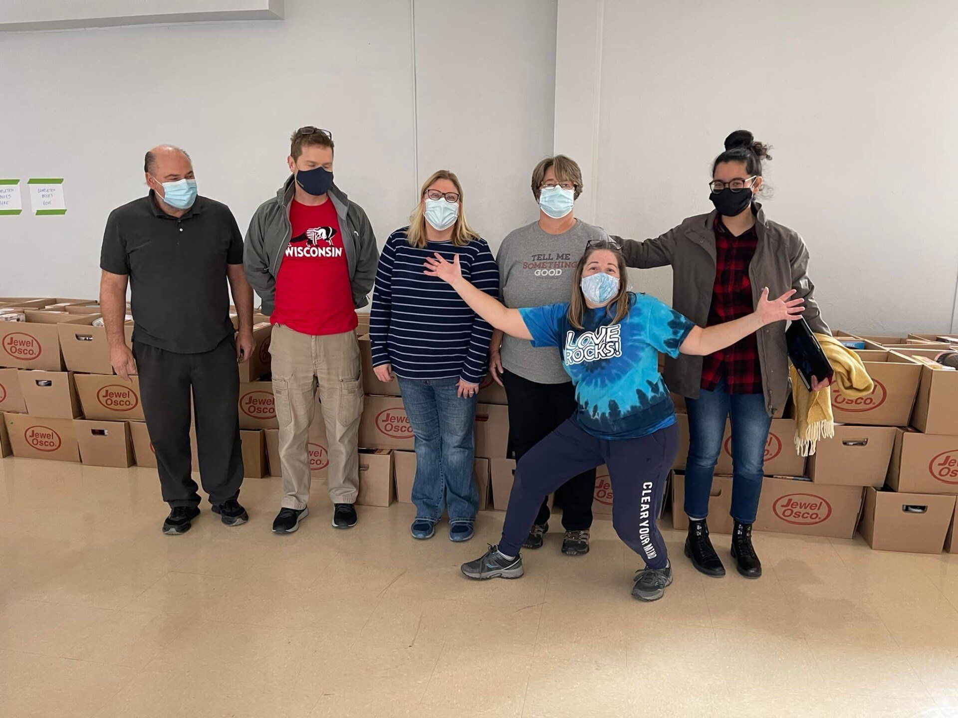A group of people wearing face masks are posing for a picture.