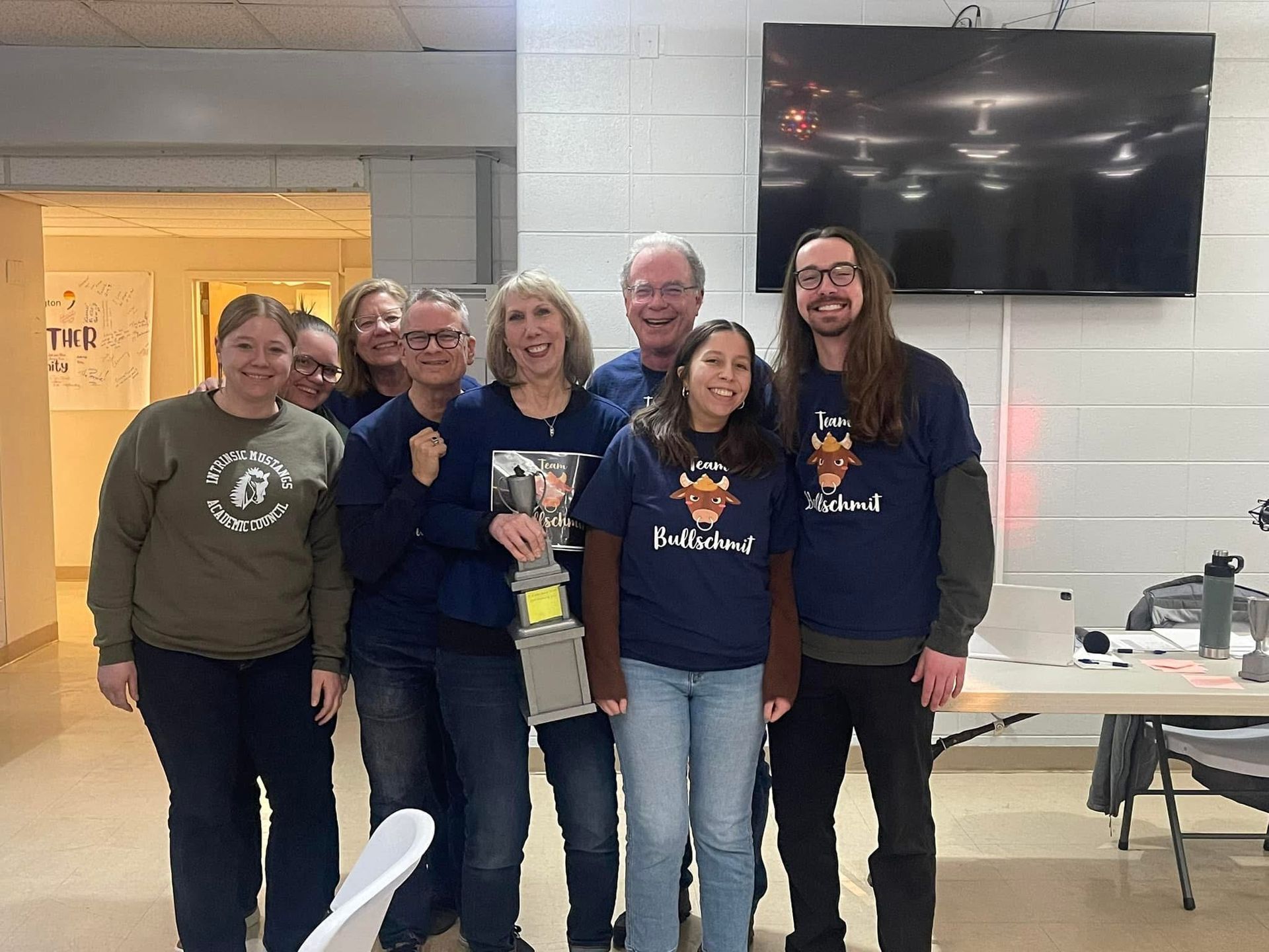 A group of people are posing for a picture in a room.