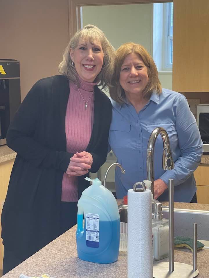 Two women are standing next to each other in a kitchen.