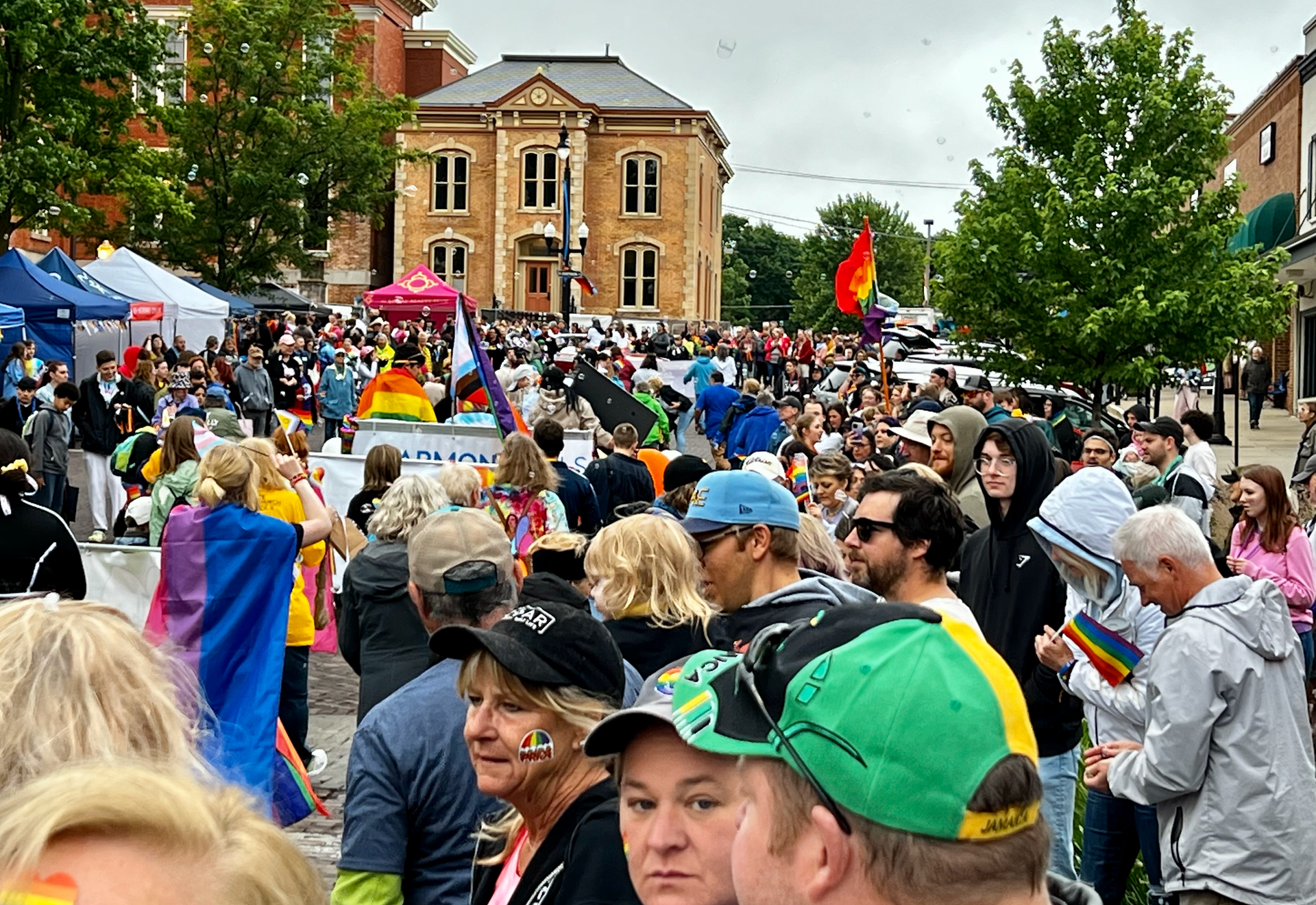 A crowd of people are gathered on a street in front of a building.