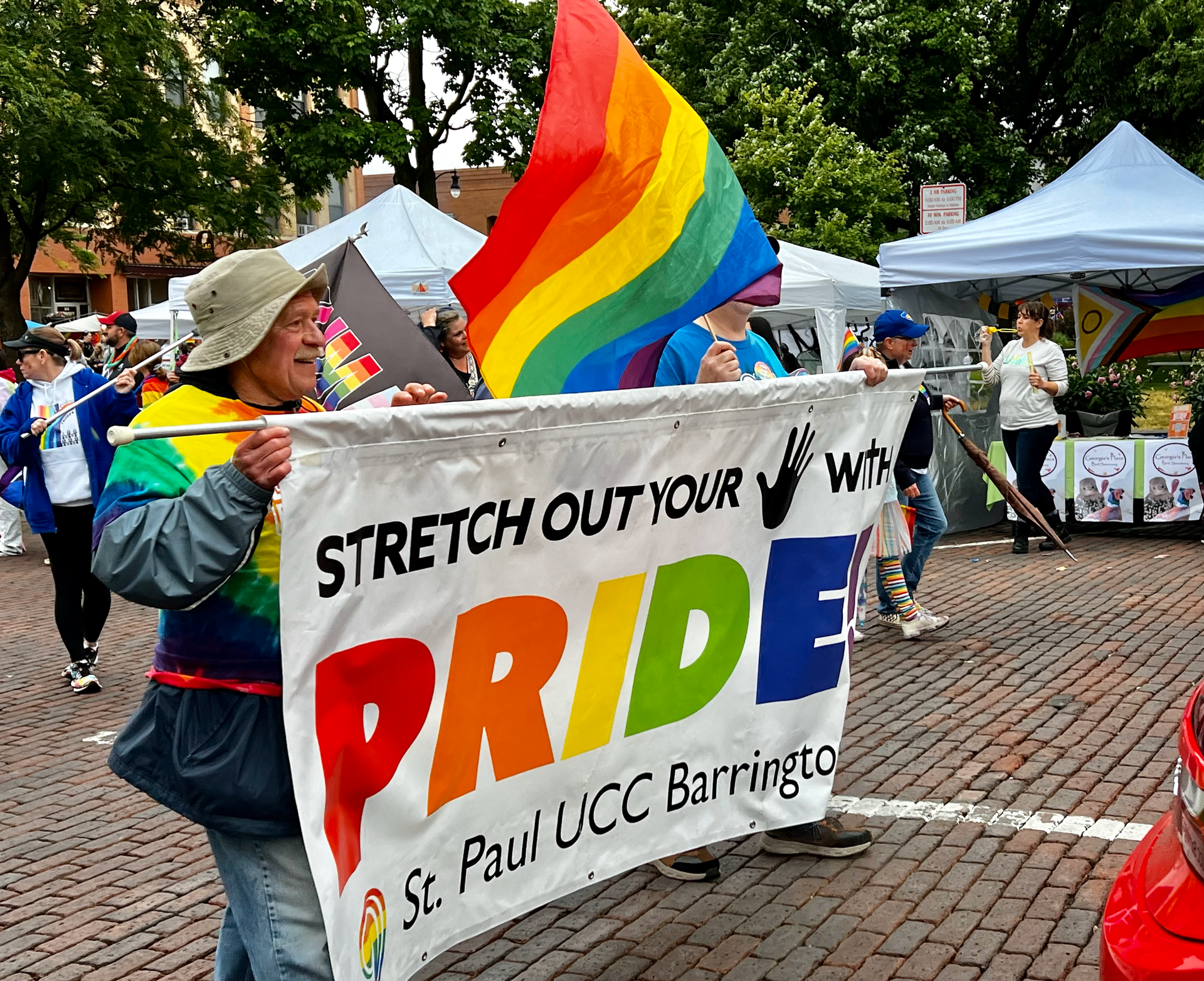 A woman holding a sign that says stretch out your pride