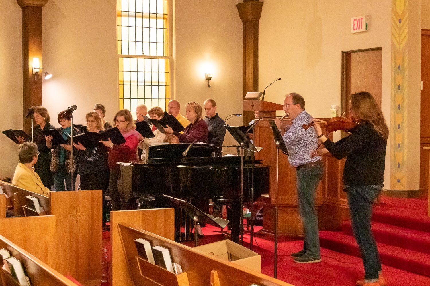 A group of people are singing and playing instruments in a church.