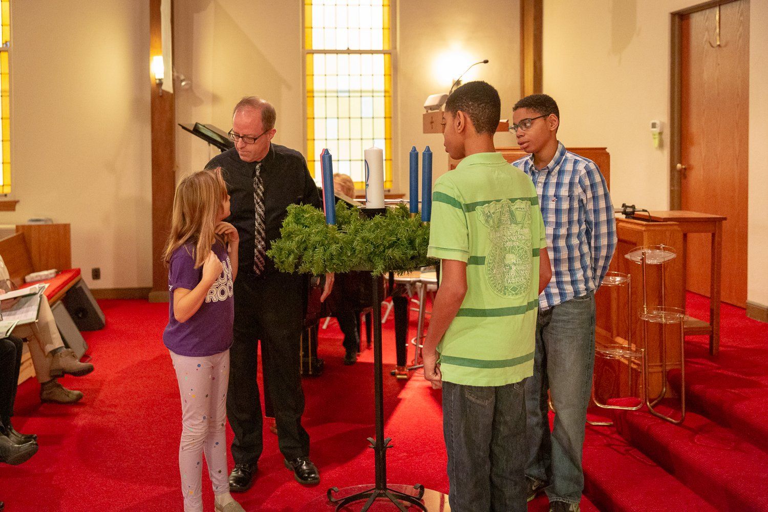 A group of people standing around a wreath in a church