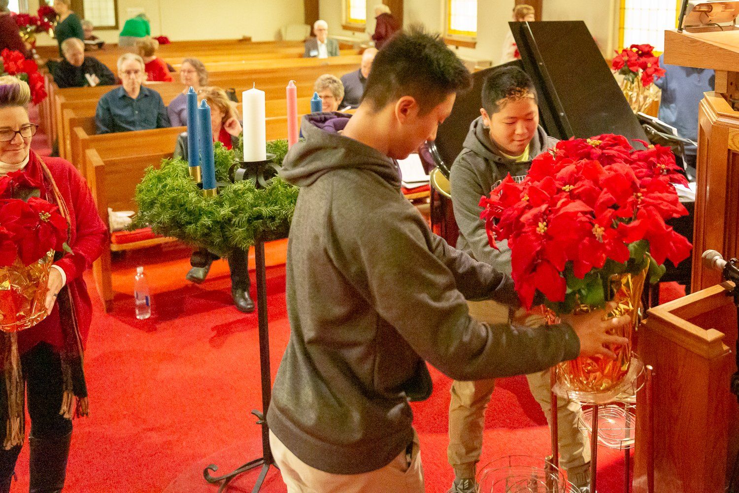A man is arranging flowers in a vase in a church.