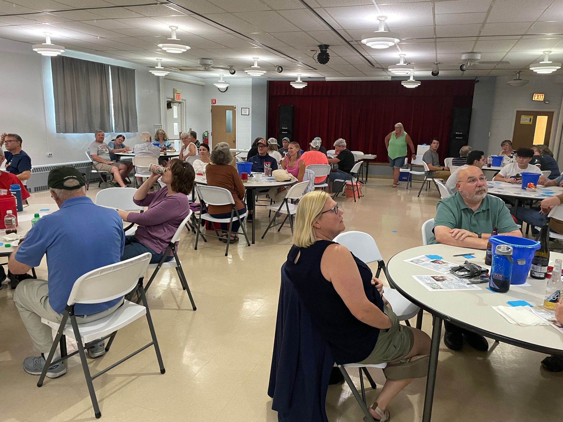 A large group of people are sitting at tables in a room.