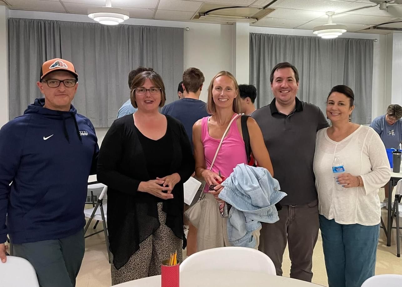 A group of people are posing for a picture in a room.