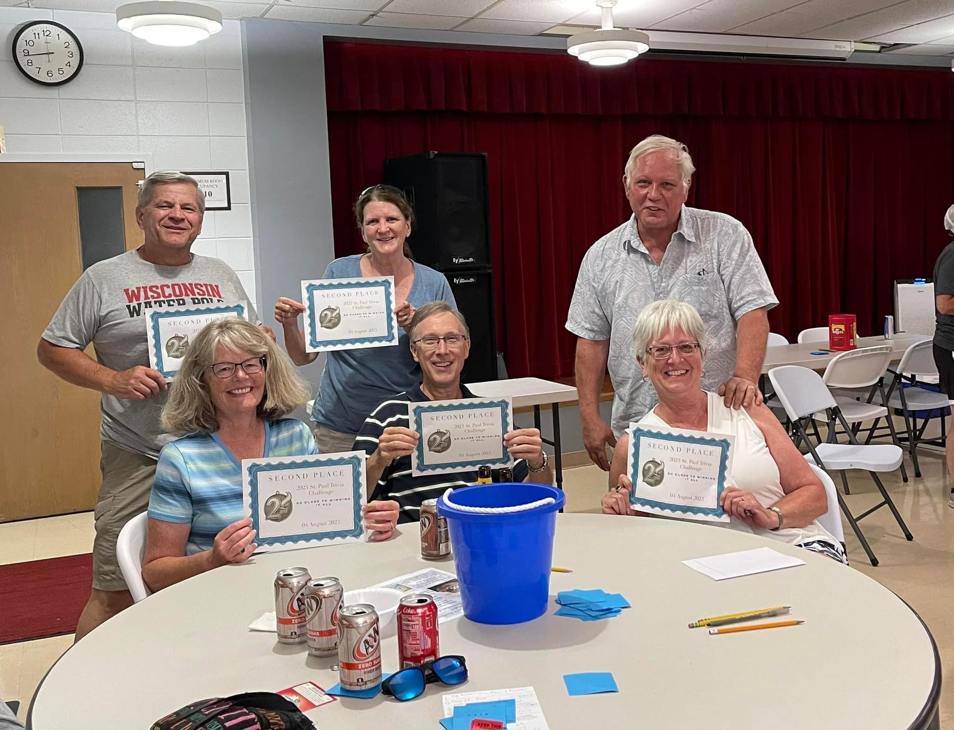 A group of people are sitting around a table holding certificates.