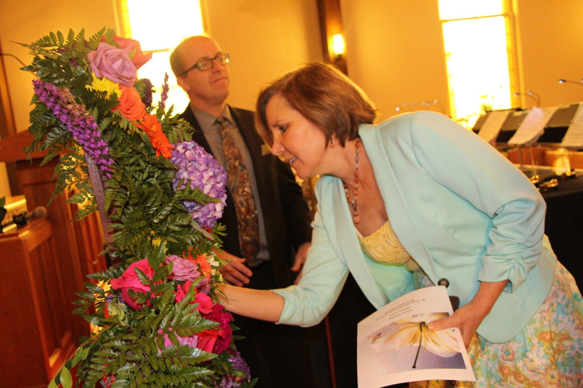 A woman in a blue jacket is looking at flowers