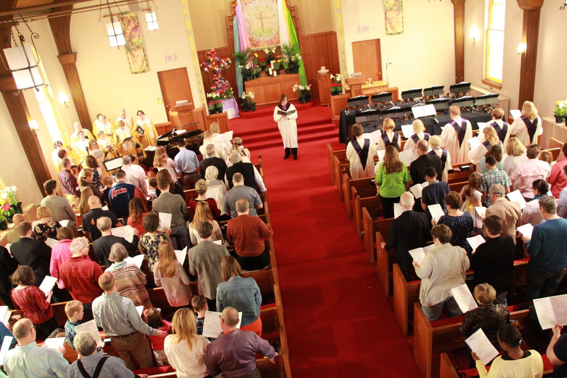 A large group of people are singing in a church
