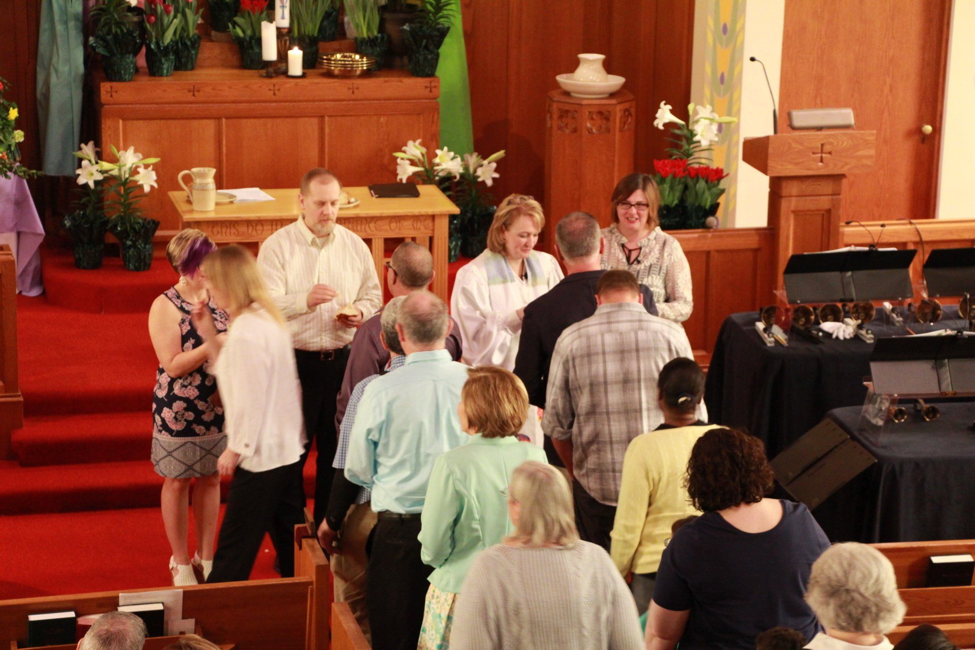 A group of people are standing in a church talking to each other