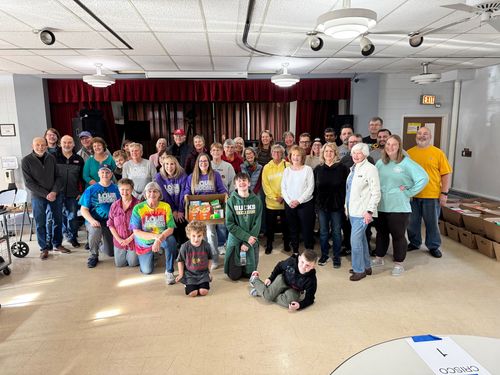 A large group of people are posing for a picture in a room.