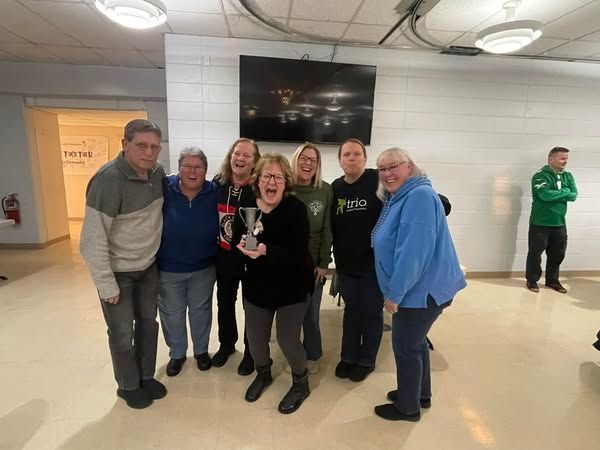 A group of people are posing for a picture in a room.
