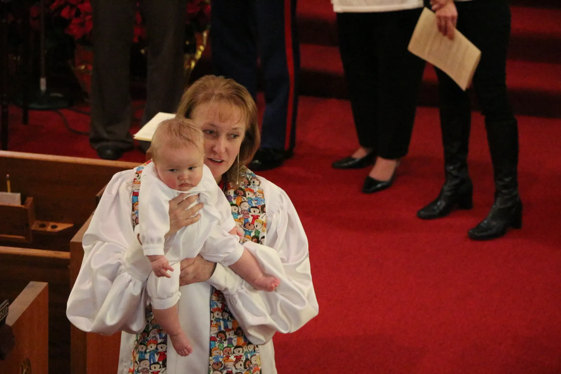 A woman is holding a baby in her arms in a church