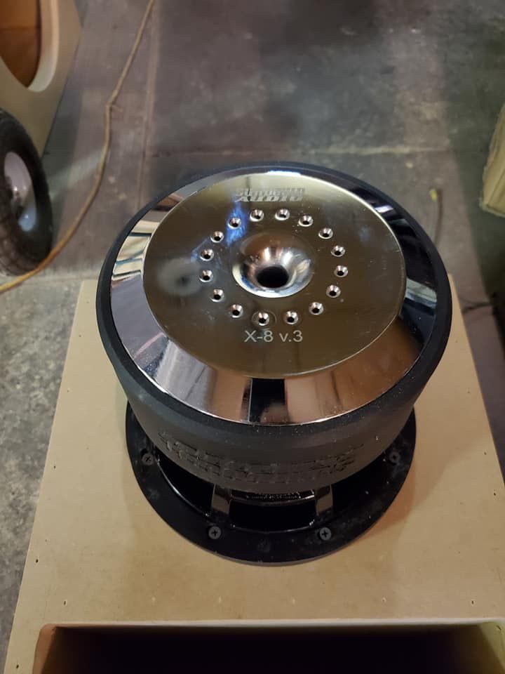 Chrome-capped subwoofer labeled 