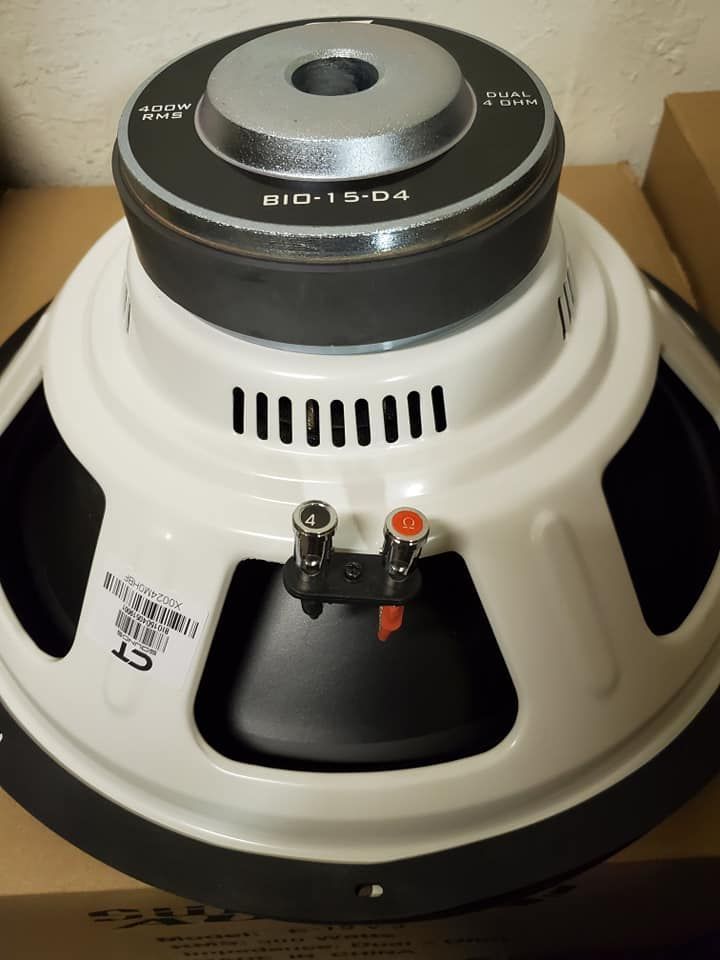 White speaker with black accents, model BIO-12-D4, with a metal center cap and wire terminals.