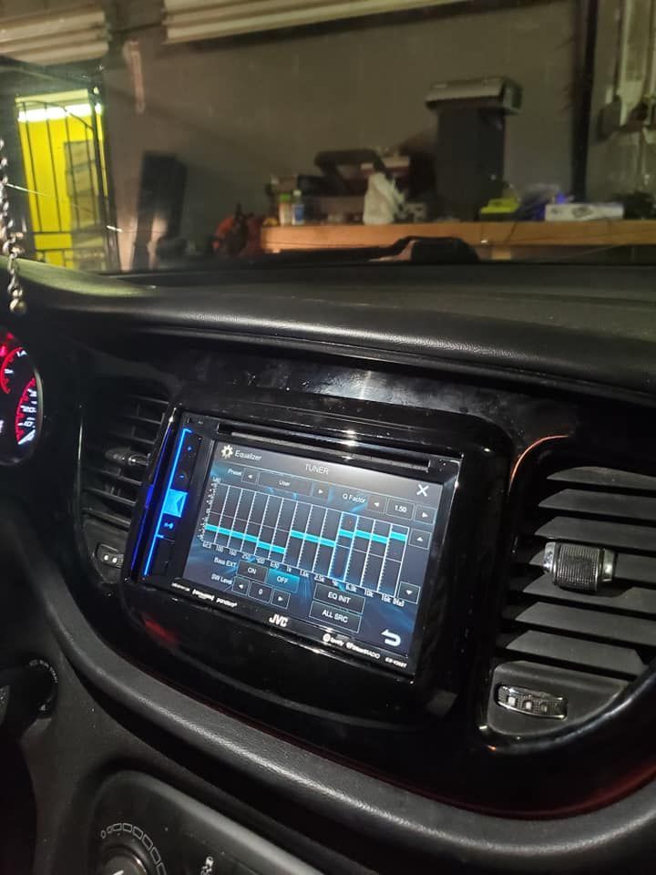 Car dashboard with a touchscreen stereo system displaying an equalizer. The dash is black, the screen shows and graphics.