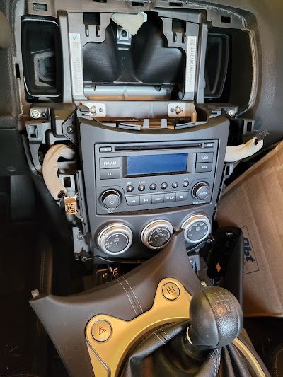 Car dashboard with the radio and climate control components exposed, showing the interior of the vehicle.