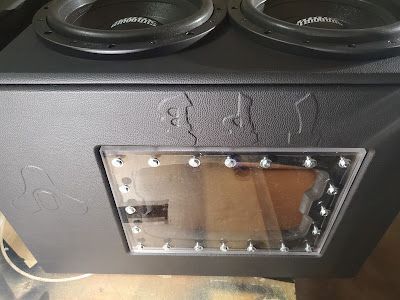 Black subwoofer box with two speakers, a clear window, and decorative etching.