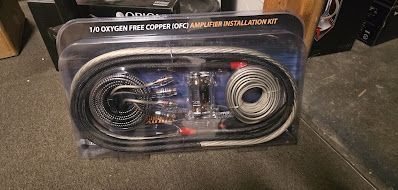 A new Orion amplifier installation kit in its packaging, with various wires, fuses, and connectors.