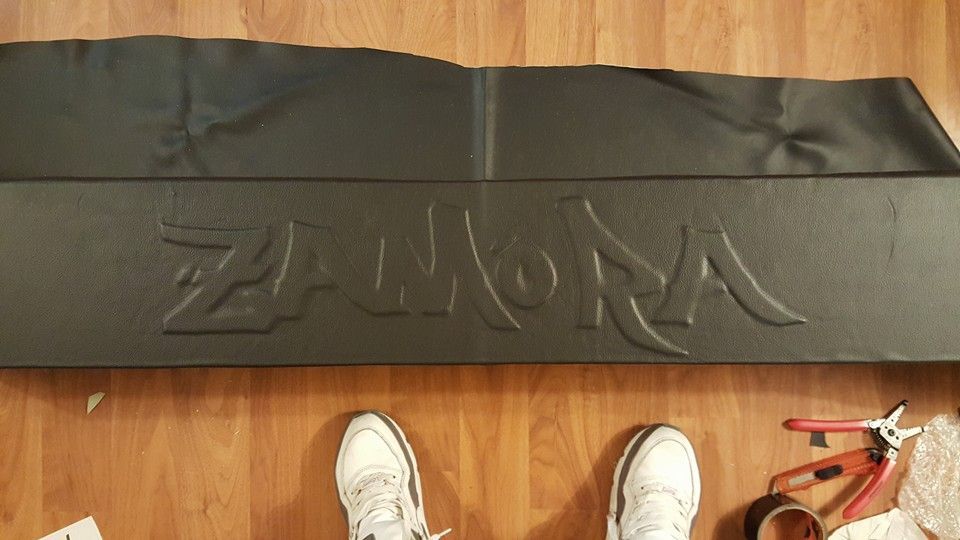 A black leather banner on a wooden floor with the word 