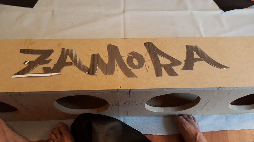 A long, tan wooden box with the word 