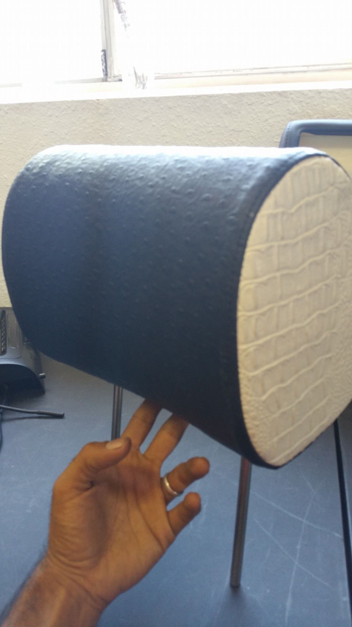 A person's hand touches a navy blue and cream-colored stool.