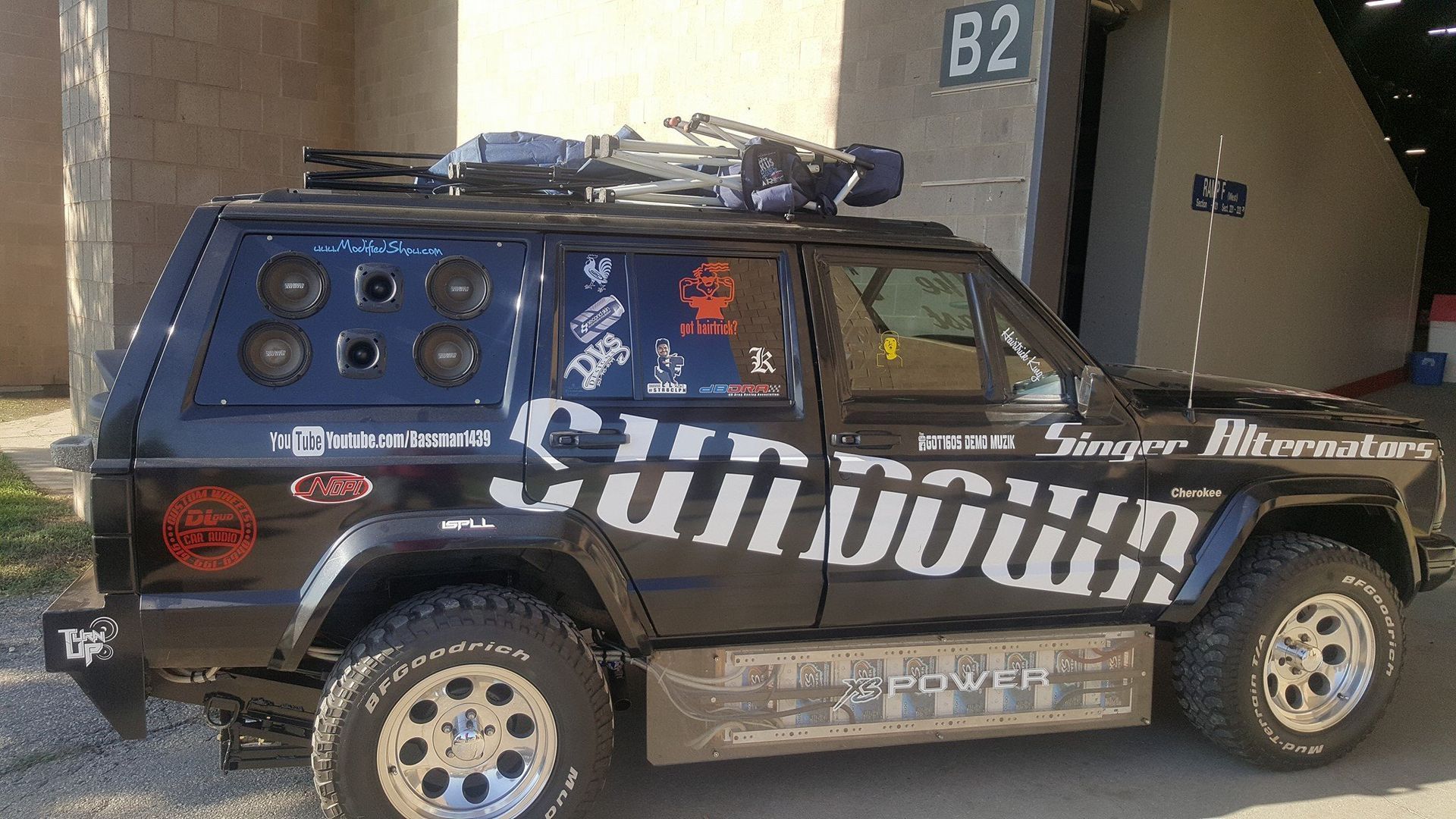 Black Jeep Cherokee customized with audio equipment, including large speakers in the back, with 