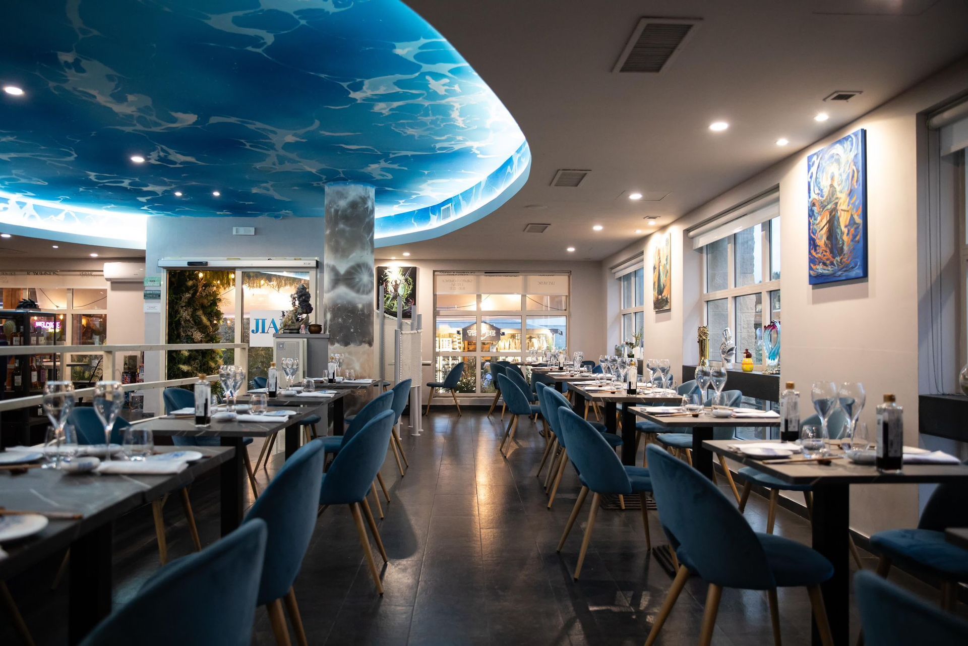 Un ristorante con tavoli e sedie e un soffitto blu