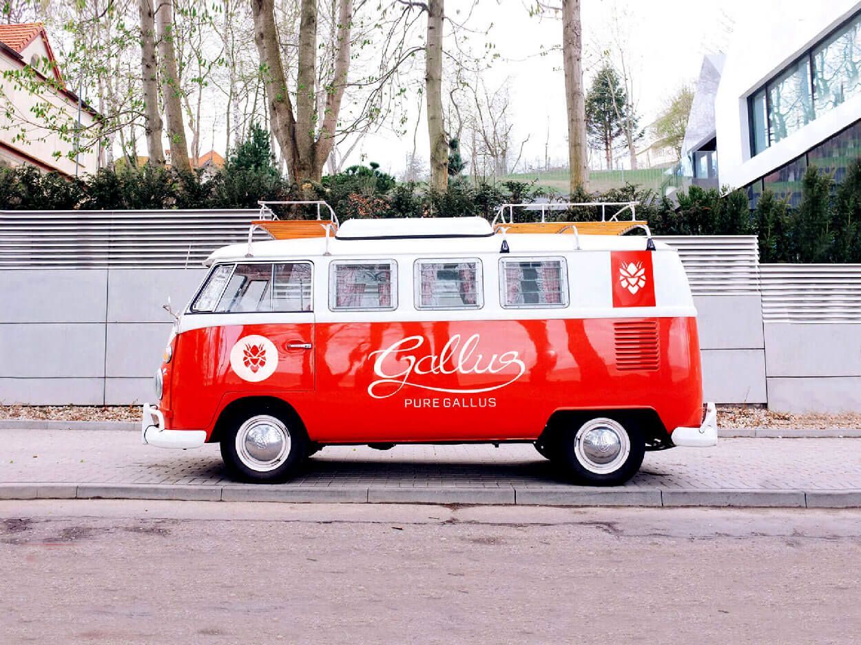 Red and white Volkswagen bus parked on a street; 