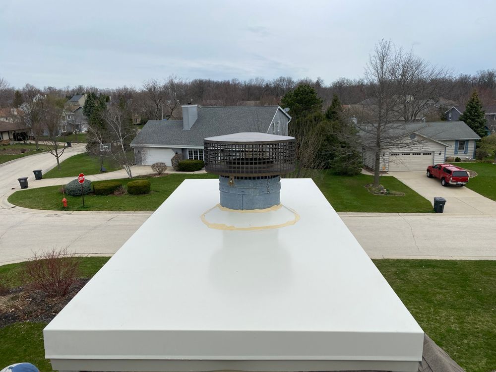An aerial view of a house with a chimney on top of it.