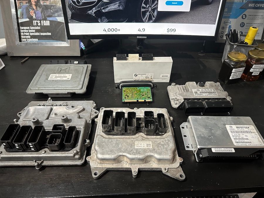 A bunch of electronic components are sitting on a table next to a computer monitor.