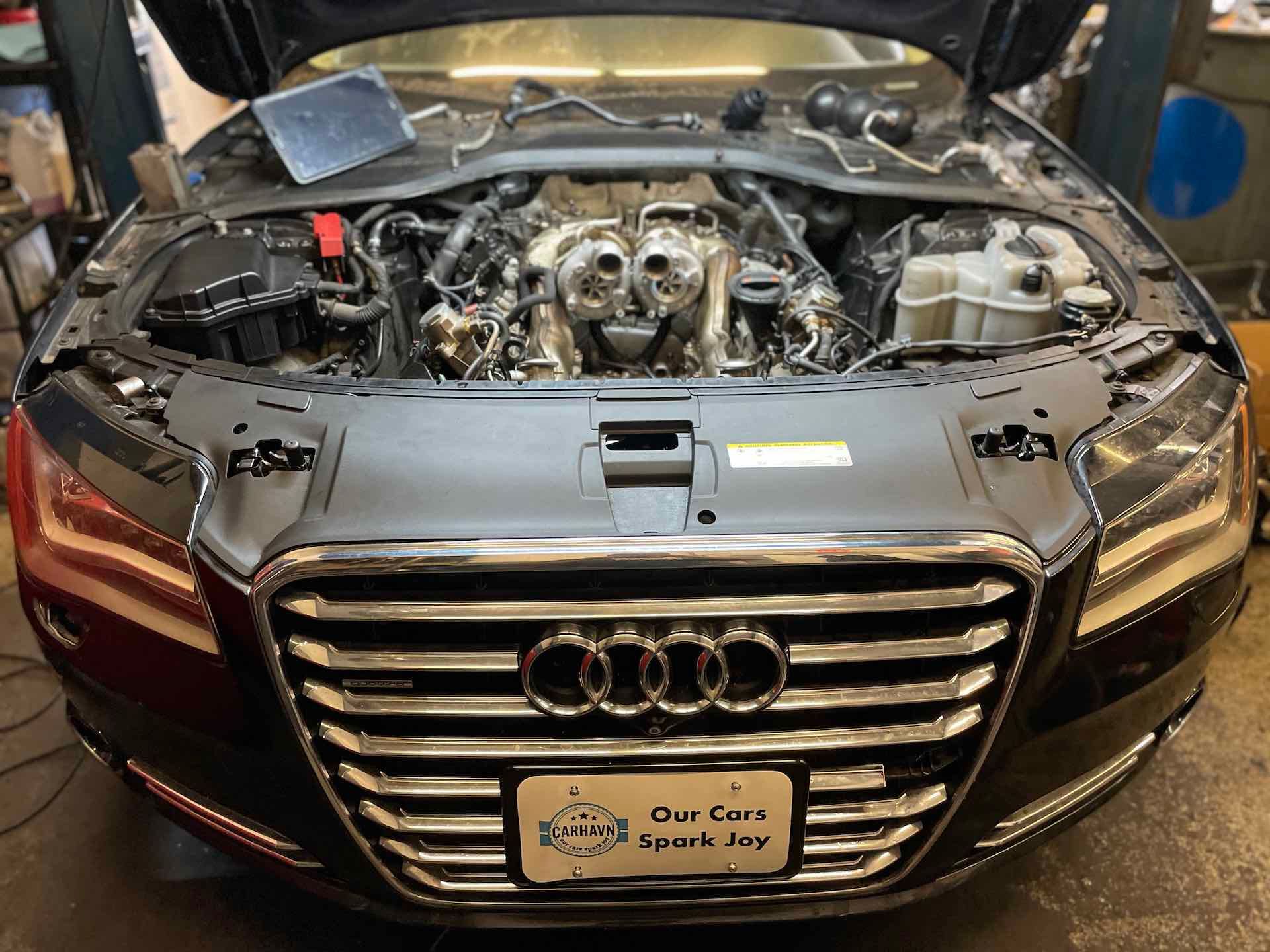 The hood of an audi is open and the engine is visible.