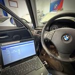 A laptop is sitting in the driver 's seat of a bmw.