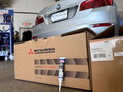 A car is sitting on top of a cardboard box that says mitsubishi turbocharger