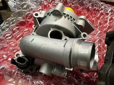 A turbocharger is sitting on top of a red bubble wrap.