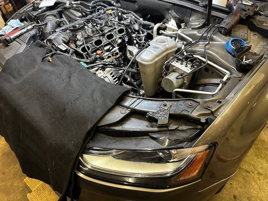 The engine of a car is being worked on in a garage.