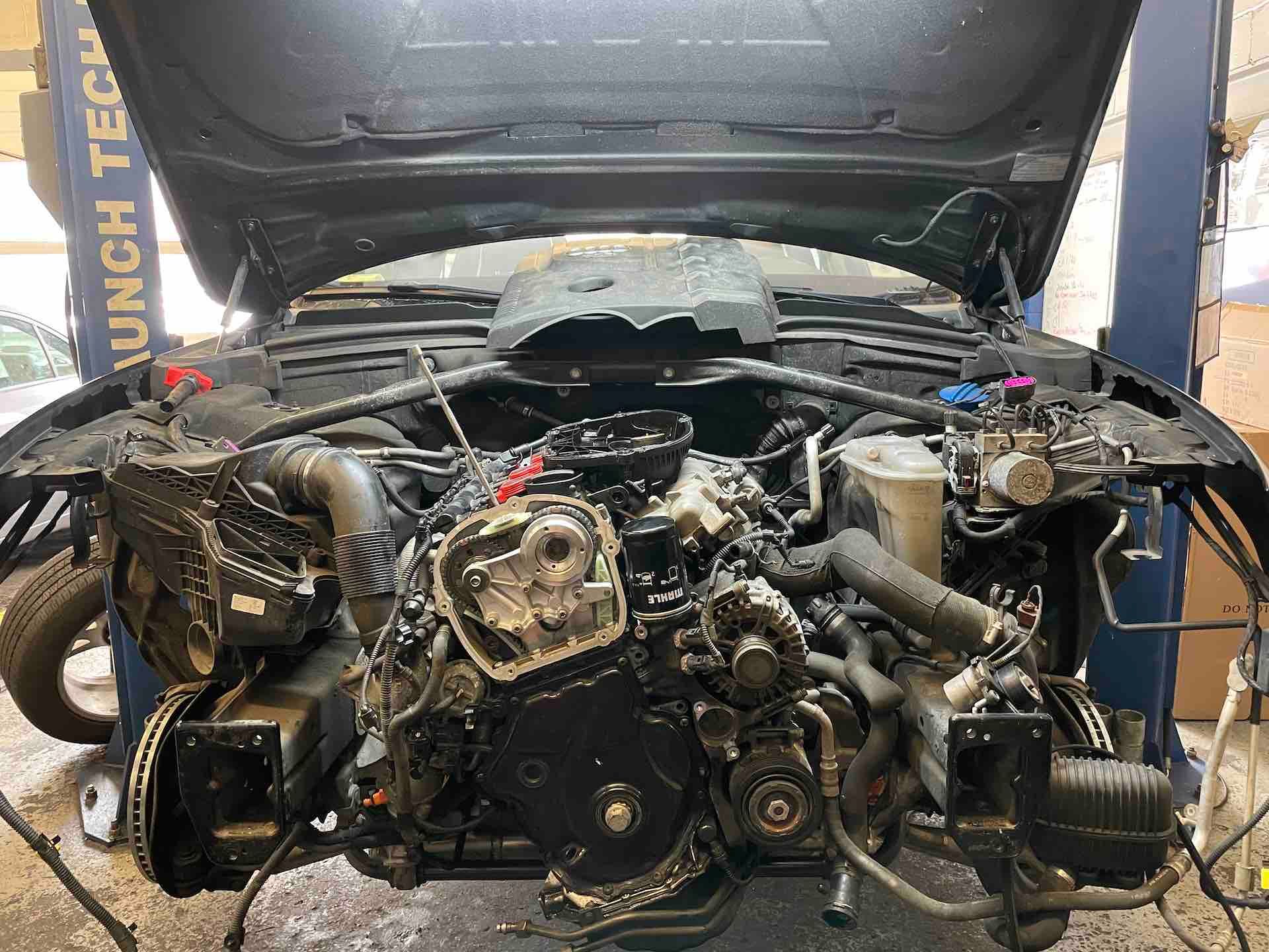 The engine of a car is being worked on in a garage.