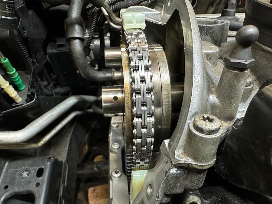 A close up of a chain in a car engine.